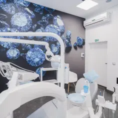Nowoczesny gabinet stomatologiczny z fotelem dentystycznym i tapetą z diamentami.