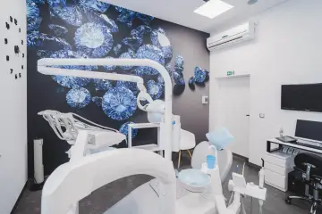 Nowoczesny gabinet stomatologiczny z fotelem dentystycznym i tapetą z diamentami.